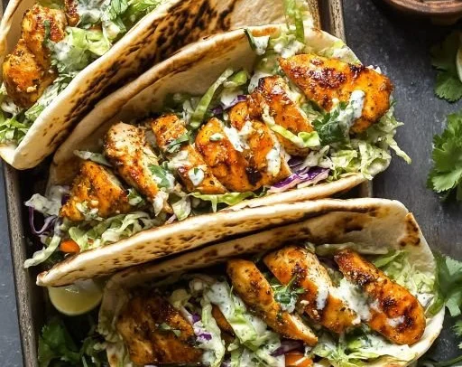 Sheet pan chicken pitas served with fresh vegetables and sauces