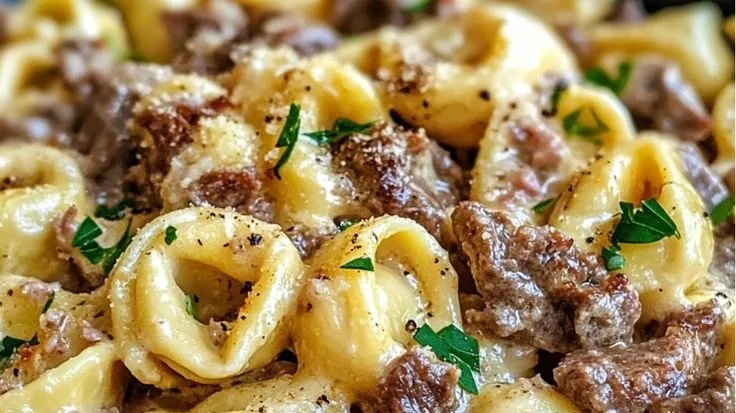 Philly Cheesesteak Tortellini Pasta garnished with fresh herbs