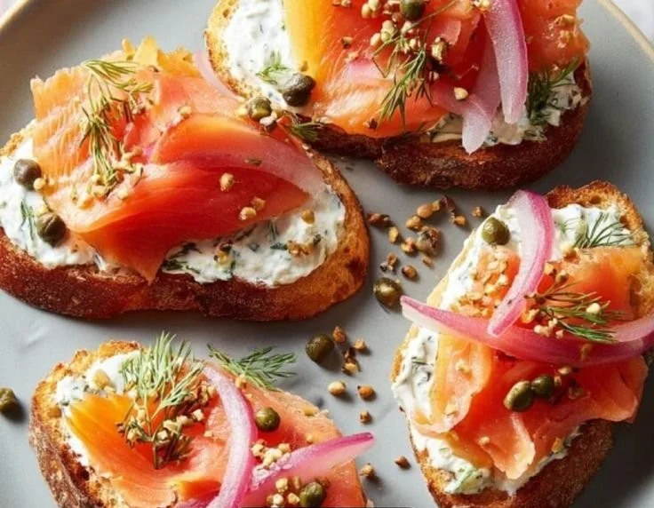 Delicious smoked salmon crostini topped with fresh herbs and cream cheese.