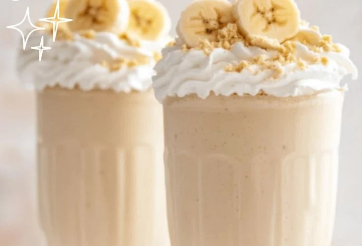 Delicious banana cream pie milkshake topped with whipped cream and banana slices.