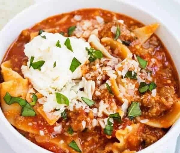 Bowl of easy lasagna soup topped with cheese and fresh herbs