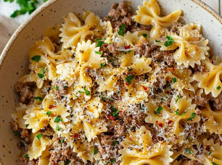 Plate of Garlic Butter Bowtie Pasta with Beef, garnished with herbs.