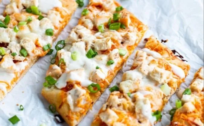 High Protein Buffalo Chicken Flatbread on a plate with fresh toppings