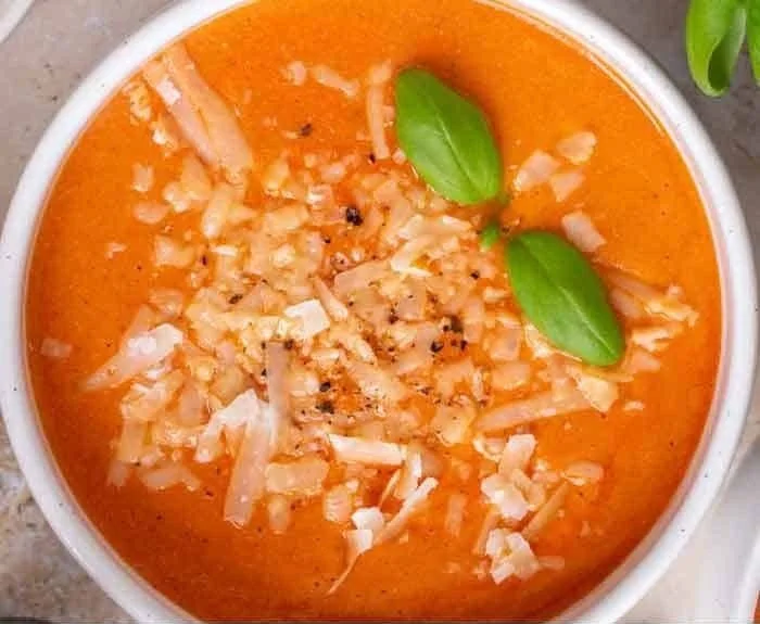 High protein tomato soup in a bowl garnished with herbs