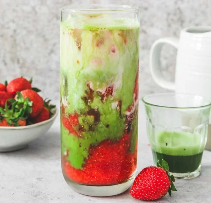 Iced strawberry matcha latte with colorful layers of matcha and strawberry puree