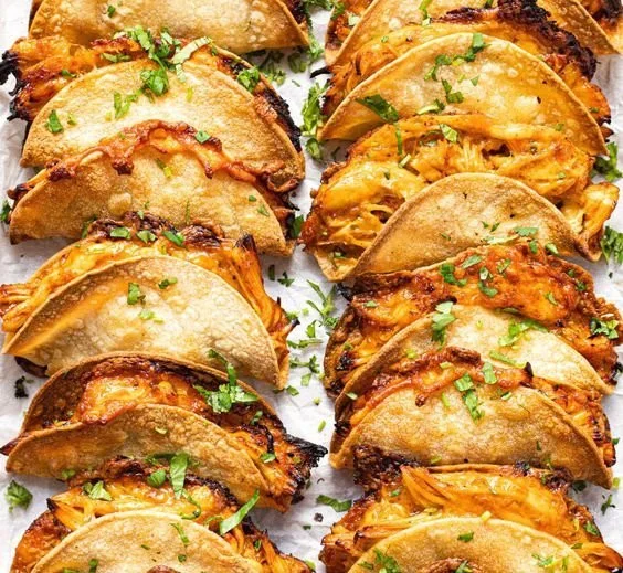 Mini baked chicken tacos served on a platter with toppings