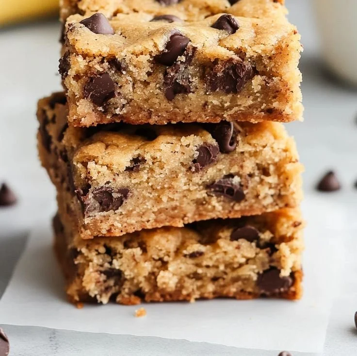 Nutty banana bread blondies served on a plate with slices and nuts