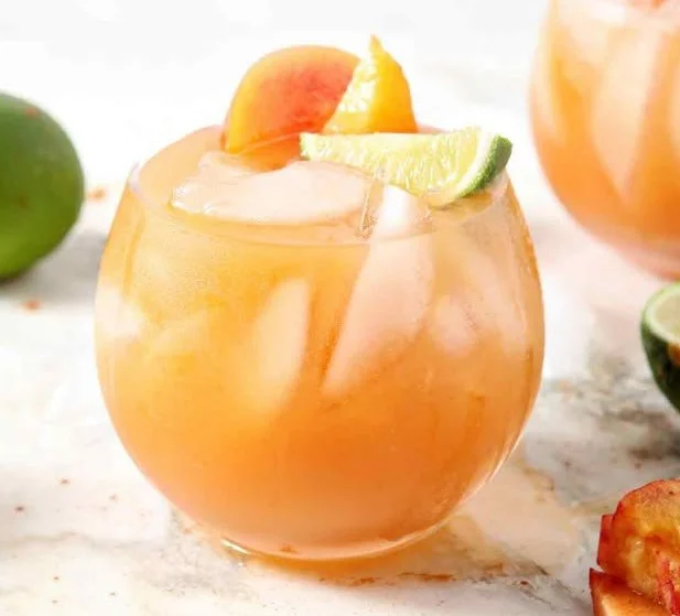 Delicious Peach Moscow Mule served in a copper mug with fresh peach slices