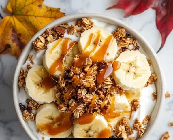 Salted caramel banana yogurt bowl topped with fresh banana slices and caramel drizzle