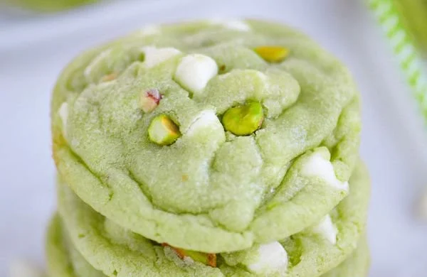 Soft and chewy pistachio pudding cookies on a plate with a bite taken out