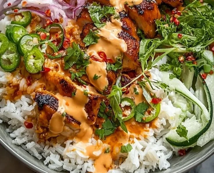 Sweet Chili Chicken Bowl topped with a Coconut Lime Drizzle, garnished with fresh herbs.