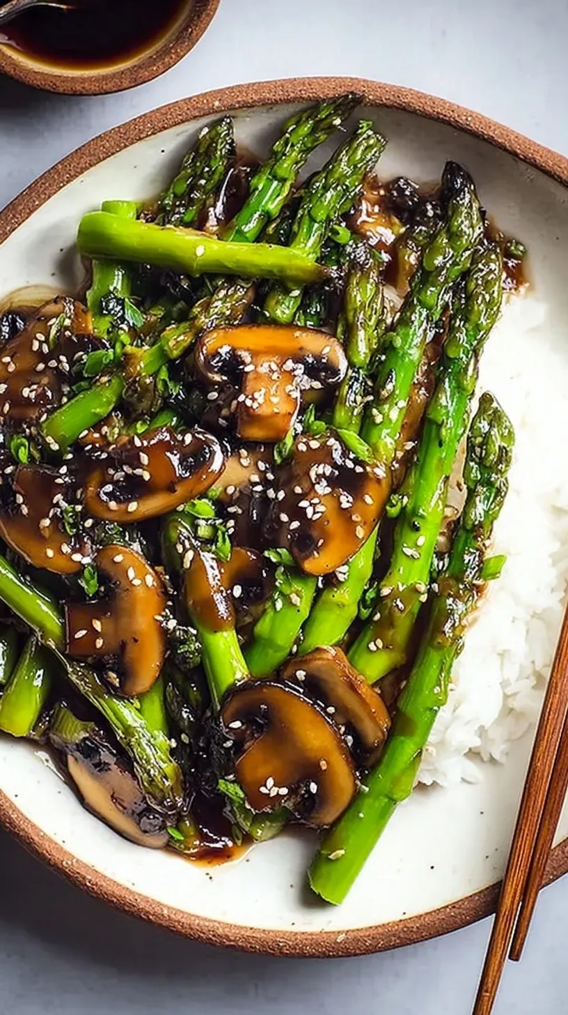 A vibrant skillet of green asparagus and golden brown mushrooms in a glossy savory glaze.
