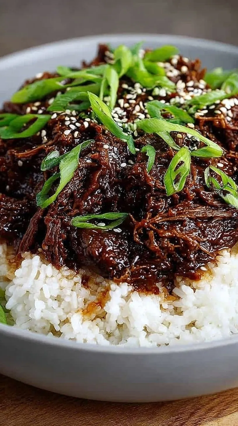 Slow cooker beef chunks in a dark savory sauce topped with green onions and sesame seeds